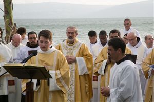 Fr. Pizzaballa, ofm, Custos of the Holy Land, stands behind a deacon proclaiming the Gospel on the shores that Jesus himself spoke the Gospel for the first time.